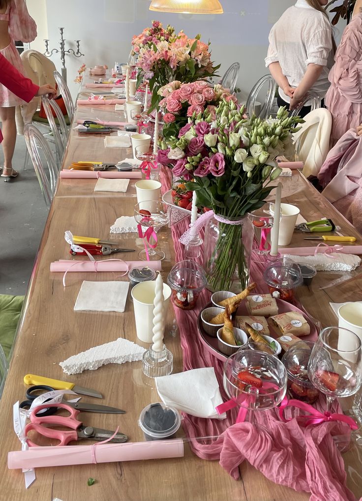 Mesa posta com flores, taças e materiais de pintura
